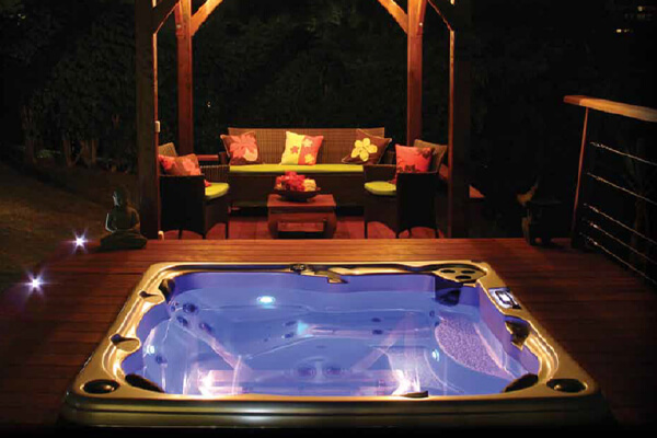 Hydropool hot tub in backyard at night